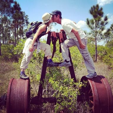 The founders sharing a kiss on an old rail cart in the Everglades